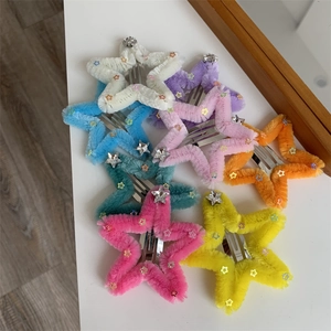 Dettaglio di fermagli a stella in peluche con paillettes colorate e strass lucidi