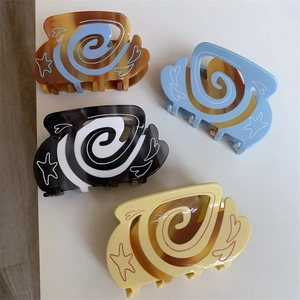 Detail showing colorful hair claws with swirl patterns and hand-drawn heart star designs