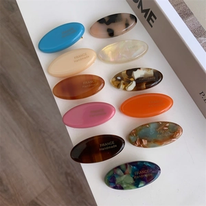 Detailed macro view of assorted acetate tortoise shell duckbill hair clips with France Handmade logo