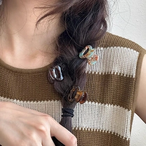 Trois mini pinces à cheveux en acétate aux motifs écaille et marbre sur une tresse