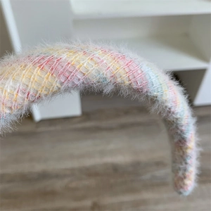 Gros plan d'un serre-tête en peluche coloré montrant une texture douce et un motif à carreaux