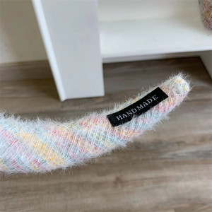 Gros plan du serre-tête en peluche à rayures colorées avec étiquette fait main