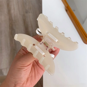 Détails d'une pince à cheveux papillon crème avec un ruban en soie et ressort interne