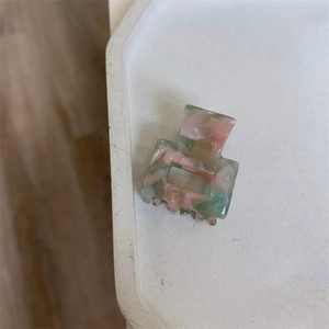 Detail of square floral acetate hair claw clip with handmade engraving in morandi pink