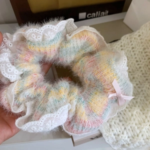 Gros plan d'un bandeau en maille rose avec bordure en dentelle blanche et nœud en soie