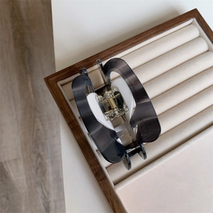 Detail view of large marble smoke grey resin hair claw clip with strong golden metal spring