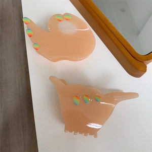 Detailed macro view of trendy OK and Shaka gesture hair claws made of acetic acid