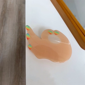 Detailed view of acetic acid hair claw clip in unique OK hand gesture shape with rainbow tips