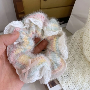 Détail du bandeau rose pelucheux avec bordure en dentelle blanche et petit nœud en soie