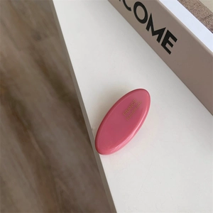 Close-up of pink acetate hair clip with gold France Handmade lettering detail