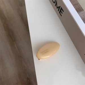 Close-up of handmade acetate duckbill hair clip in cream beige with gold lettering