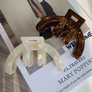 Detail of tortoise shell and cream acetate hair claws on a magazine for styling