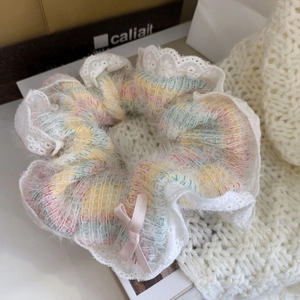 Gros plan sur un bandeau en maille arc-en-ciel avec dentelle et nœud en satin rose