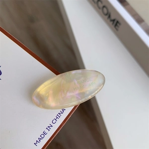 Close-up of iridescent acetate hair clip with engraved FRANCE Handmade lettering