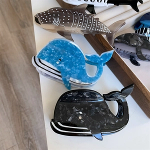 Détail de pinces à cheveux baleine et requin en acétate avec textures marbrées