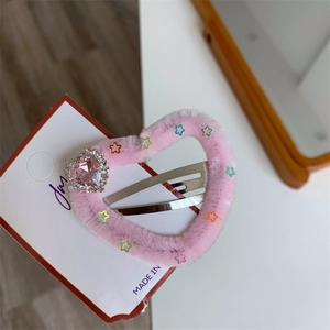 Dettaglio molletta a cuore in peluche rosa con strass a cuore e decorazioni a stella