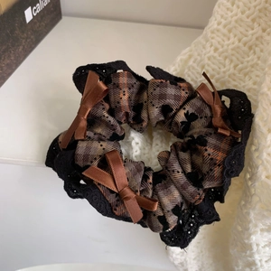 Close-up of vintage brown plaid scrunchie with black lace trim and satin bows detail