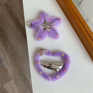 Dettaglio di fermagli per capelli in peluche viola a forma di stella e cuore