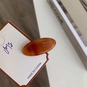 Detailed view of an acetate tortoise shell hair clip with gold France Handmade logo