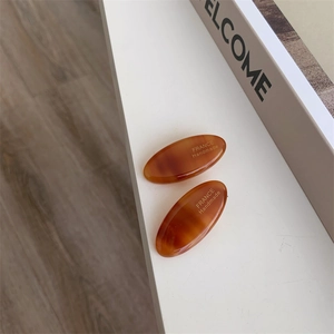 Detailed close-up of tortoise shell acetate hair clips with gold handmade lettering