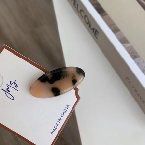 Detailed close-up of tortoise shell acetate hair clip with gold France handmade logo