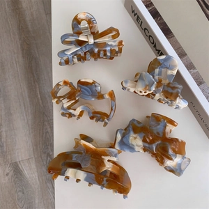 Detailed view of large acetate hair claws in vintage amber and blue marble textures