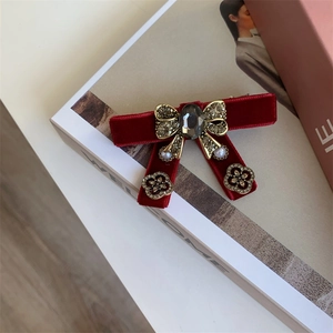 Detailed view of luxury velvet bow hair clip with rhinestones and pearl pendant