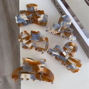 Close-up of tortoise shell acetate hair claws in various elegant butterfly and geometric shapes