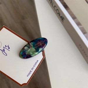 Detail of marble pattern acetate hair clip with gold lettering on display card