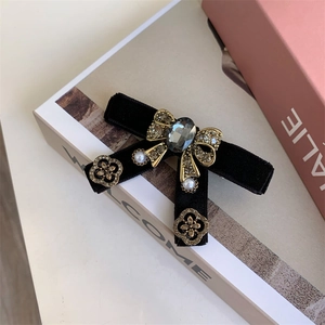 Detail of vintage velvet bow hair clip with crystal center and pearl accents
