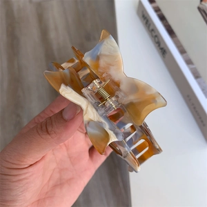 Detail of amber marble texture acetate hair claw clip with bow shape and metal spring