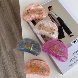 Pinces à cheveux chic en acétate avec strass colorés et motifs marbrés sur magazines