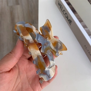 Close-up of tortoise shell acetate hair claw clip with elegant butterfly hollow design