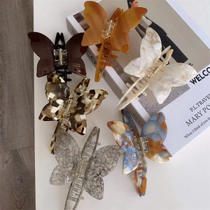 Detail of six acetate butterfly hair claws in amber, marble, and tortoiseshell patterns
