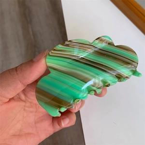 Detail view of large acetic acid hair claw clip with marble green and brown pattern