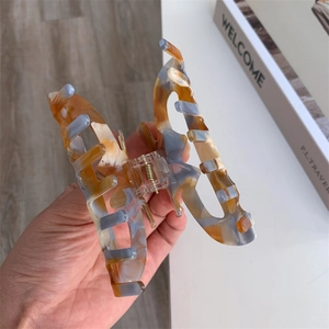 Close-up of marble texture acetate hair claw clip with bow shape and metal spring