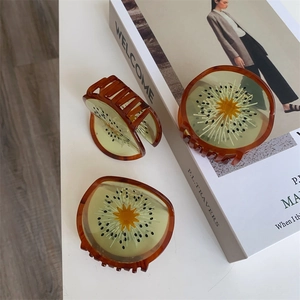 Detailweergave van doorschijnende kiwi haarklemmen van acetaat op wit oppervlak