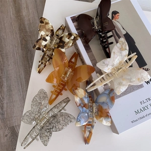 Detail view showing a variety of colors and marbled patterns on acetate butterfly hair claws