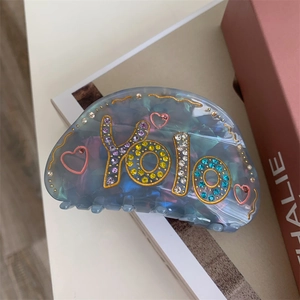Détail de la pince à cheveux cœur avec strass YOLO sur acétate dégradé bleu et violet