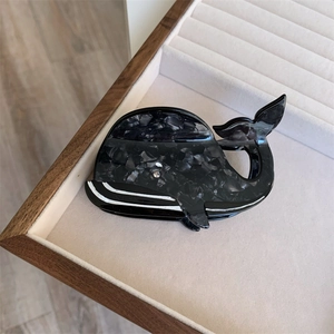 Détail de la pince à cheveux en acétate forme baleine motif marbre dans un coffret