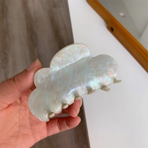 Detailed view of large cloud-shaped hair claw clip with pearlescent acetic acid texture