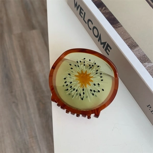 Detailopname van een creatieve kiwi haarklem met een transparante acetaat afwerking