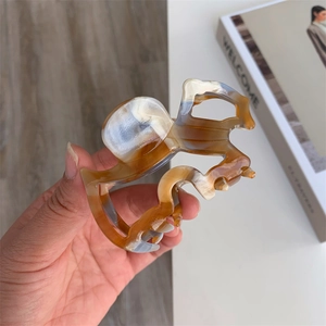 Detailed view of the amber and blue-grey tortoiseshell texture on the acetate hair claw