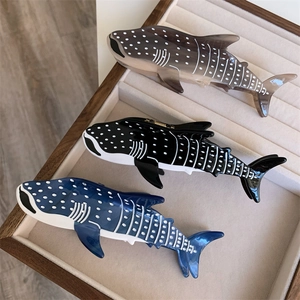 Vue détaillée de trois pinces à cheveux en acétate en forme de baleine, gris, noir et bleu