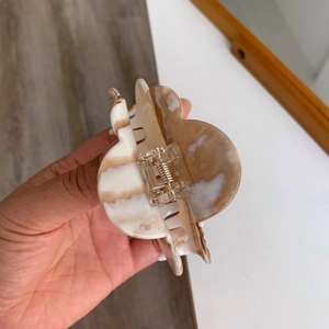 Close-up of thick acetate shark hair claw clip with brown and white marble texture