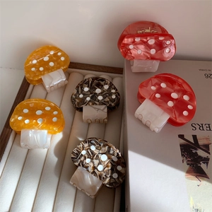 Macro detail of colorful mushroom hair claws in marble acetate with white polka dots