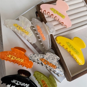 Macro detail of assorted large acetate hair claws with embossed JE T'AIME lettering