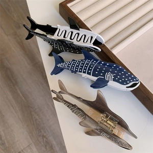 Détail de pinces à cheveux requin en acétate avec pois bleus et texture marbrée sur plateau