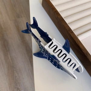 Détail d'une pince à cheveux requin-baleine en acétate bleu avec des points blancs