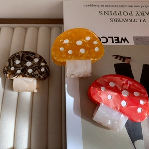 Three colorful mushroom hair claws in yellow, red, and marble brown with white polka dots